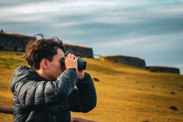 Turista con binoculares, observando el paisaje de la Isla de Pascua.