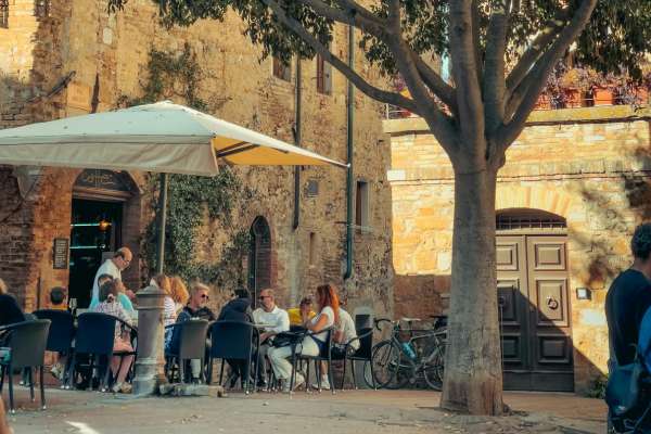 imagem de uma praça com pessoas tomando café para falar sobre roteiro de viagem na Itália
