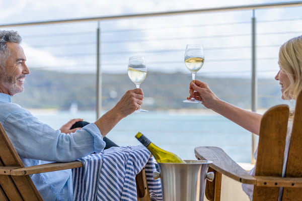 Pareja bebiendo vino en la cubierta de un crucero.