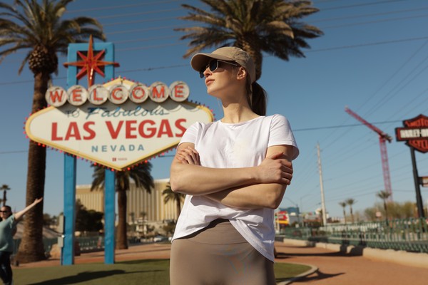 Mujer posando para la foto con los brazos cruzados junto al letrero de Bienvenidos a Las Vegas, Nevada.