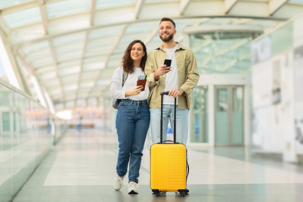 Pareja caminando en aeropuerto felices