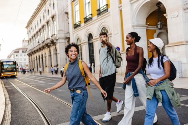 Grupo de turistas sonrientes caminando por las calles de Lisboa, Portugal.
