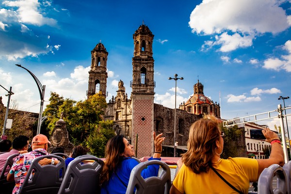 Un grupo de personas explorando el centro de la Ciudad de México en el autobús turístico.