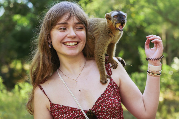 Turista interactúa con un lémur mientras explora Madagascar.