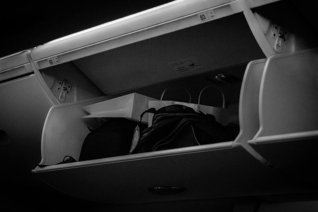 Imagem do compartimento de bagagens de um avião, em um artigo de blog sobre tamanho de mala de bordo