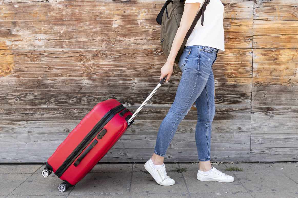 Pessoa segurando uma bolsa de couro marrom no embarque, representando uma bagagem de mão de voo internacional