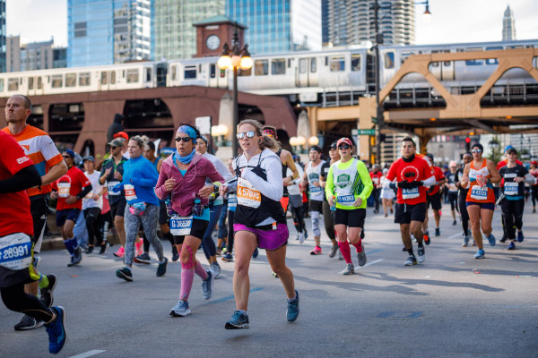 Atletas corriendo la Maratón de Chicago por debajo del famoso tren “L”.