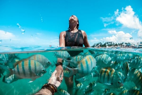 Mujer nadando en las aguas de Porto, durante la mejor época para viajar a Brasil.