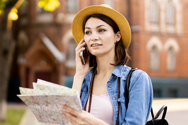 Mujer turista al teléfono con mapa en la mano