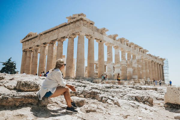 Mujer relajándose mientras mira el templo del Partenón
