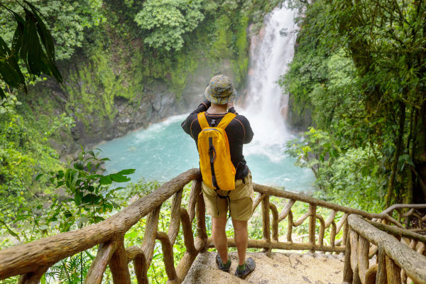 Hombre joven haciendo senderismo en selva tropical verde, Costa Rica, Centroamérica.