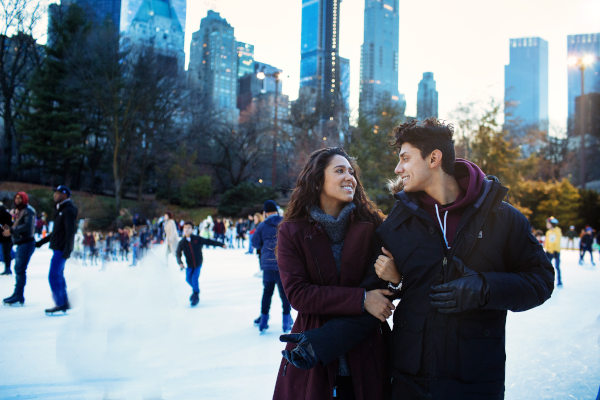 Pareja joven en la pista de patinaje de hielo Wollman Rink en Central Park, Nueva York.