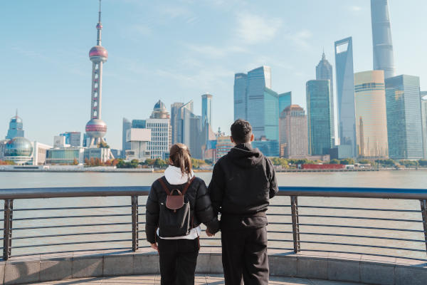 Pareja de turistas con vistas hacia la ciudad futurista de Shanghái en un día soleado