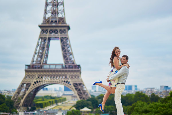 Pareja de turistas ecuatorianos posando frente a la Torre Eiffel en París, durante un viaje a Europa.