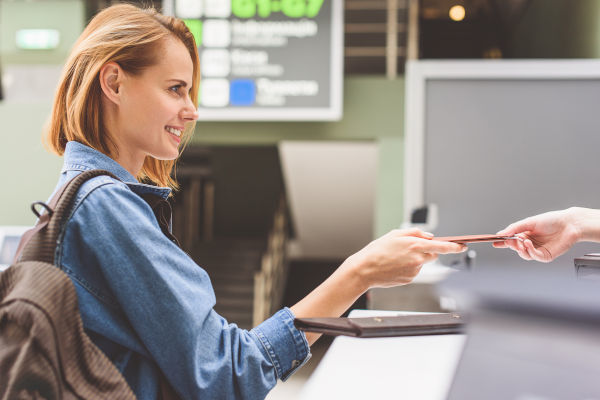 turista mujer en un aeropuerto presentando su pasaporte.