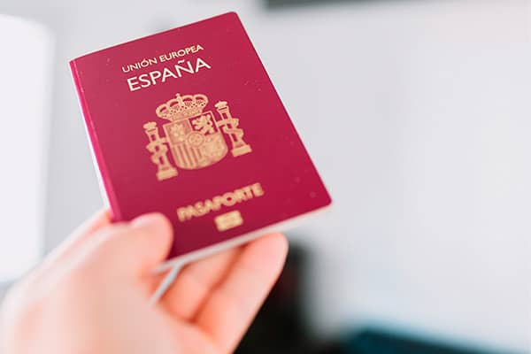 una mano sosteniendo un pasaporte español