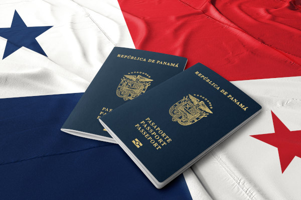 Dos ejemplares de pasaporte panameño sobre la bandera de Panamá