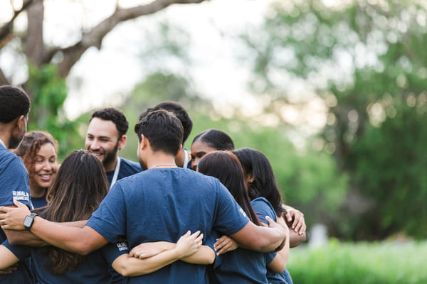 Grupo de personas abrazadas al aire libre