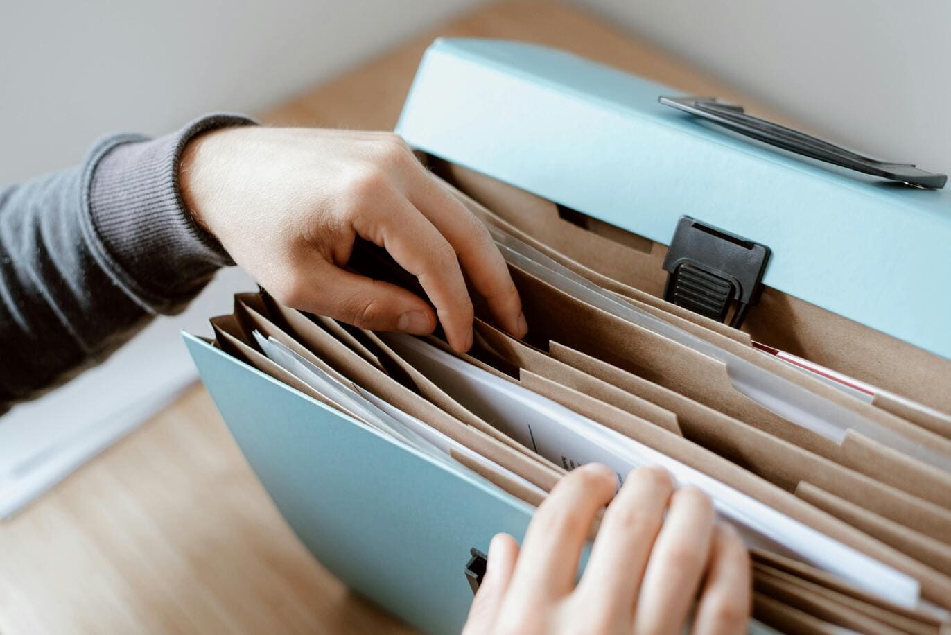 Imagem de mãos de uma pessoa preenchendo um formulário, para artigo de blog sobre documentos necessários para tirar passaporte
          