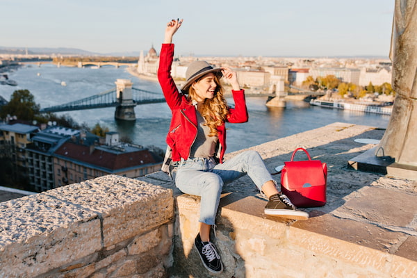  imagem de mulher loira, de chapéu, em ponto turístico em viagem pela Europa