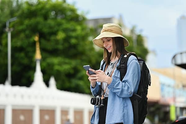 Mulher jovem usando seu smartphone enquanto faz passeios turísticos