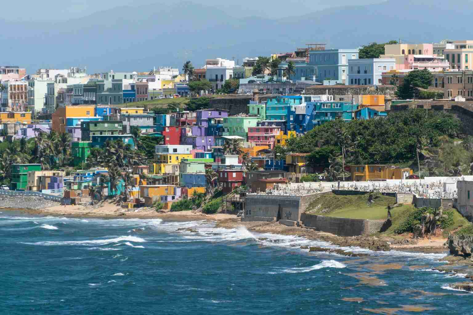 Vista panorâmica das casas coloridas de La Perla à beira-mar em San Juan, ilustrando artigo sobre viagem para Porto Rico 2025.