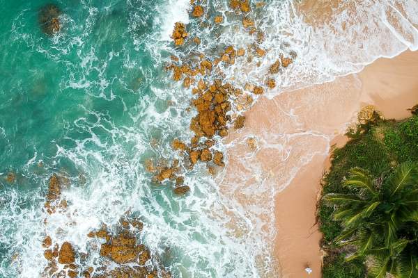 imagem de pessoas caminhando em praia paradisíaca