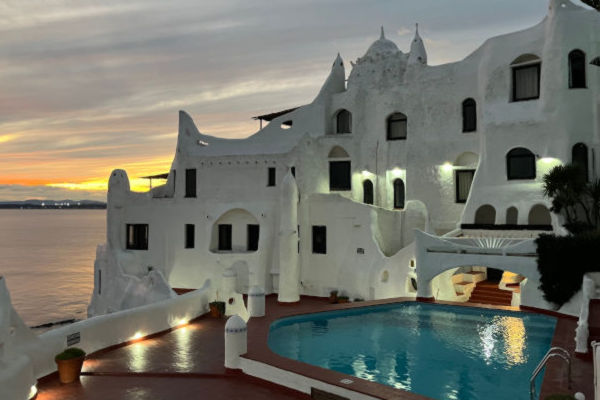 Mujer mirando el puerto con veleros en Punta del Este durante un día soleado.