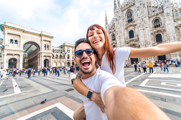 Pareja feliz tomándose una selfie en frente a la Catedral del Duomo en Milán