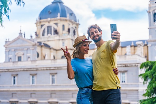 Pareja de turistas tomándose una selfie durante un viaje a Madrid en verano.