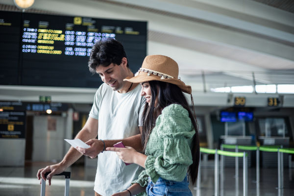 Pareja latina sonriendo en el aeropuerto.