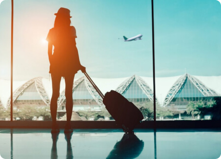Mulher com mala no terminal do aeroporto, pronta para viajar.