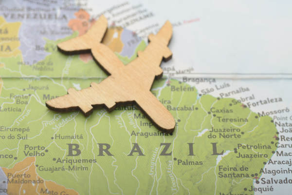 Saindo do Brasil: viagem de avião com passaporte brasileiro e mapa vibrante.