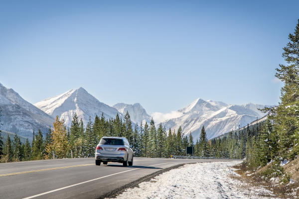 Coche en una ruta escénica en las Montañas Rocosas canadienses durante un soleado día de invierno en Banff, Canadá.