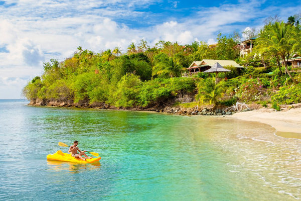 Hombre joven en un kayak en el océano de la isla Santa Lucía.