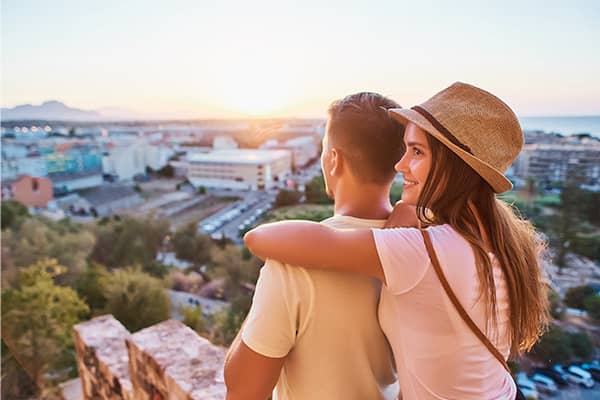 una pareja abrazada mirando el atardecer