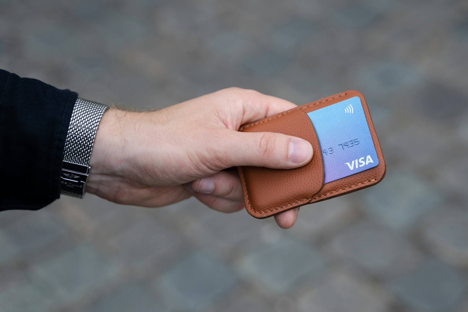 imagem de mãos segurando uma carteira com alguns cartões de crédito, em artigo de blog da Assist Card sobre seguro viagem do cartão de crédito