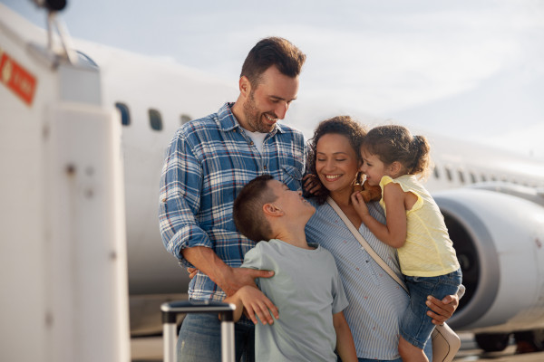 Familia de 4 personas esperando para subir a un avión