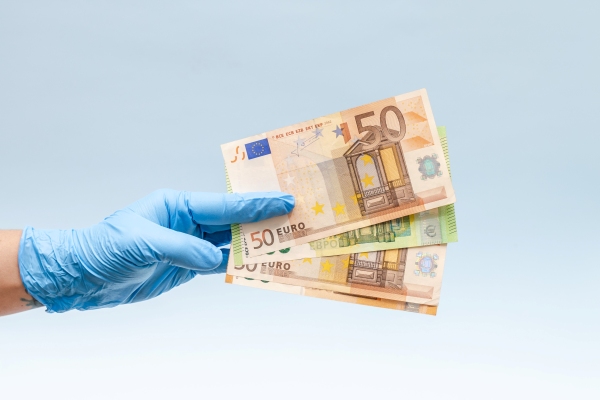 Reales brasileños en efectivo con una lapicera junto a la bandera de Brasil.
