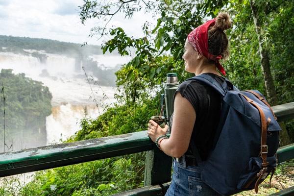 turista tomando mate frente a las cataratas del Iguazú