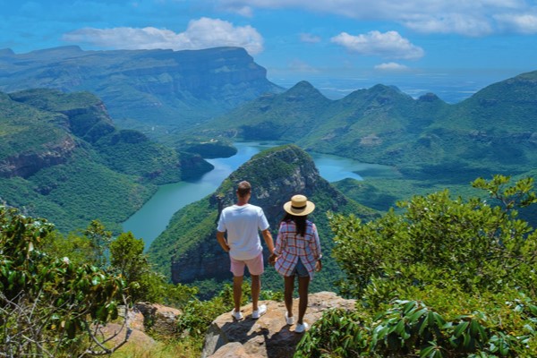 Pareja turista de la mano observando vista panorámica en el cañón del Río Blyde