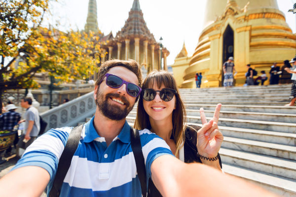 Pareja viajera tomando una selfie en los templos del Gran Palacio en Bangkok.