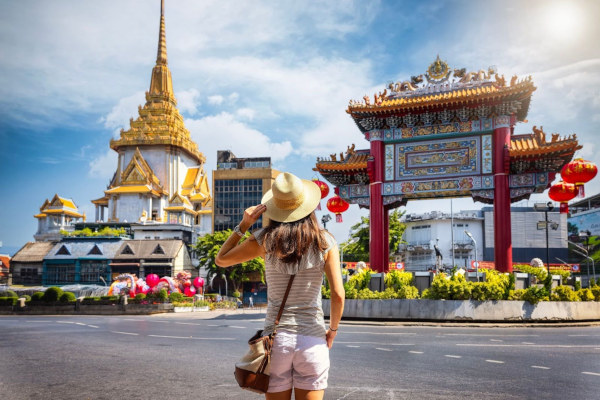 Mujer turista parada frente a la Puerta del Barrio Chino en la famosa Yaowarat Road, Bangkok, Tailandia.