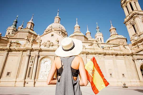 Turista con bandera de España frente a la catedral de Zaragoza