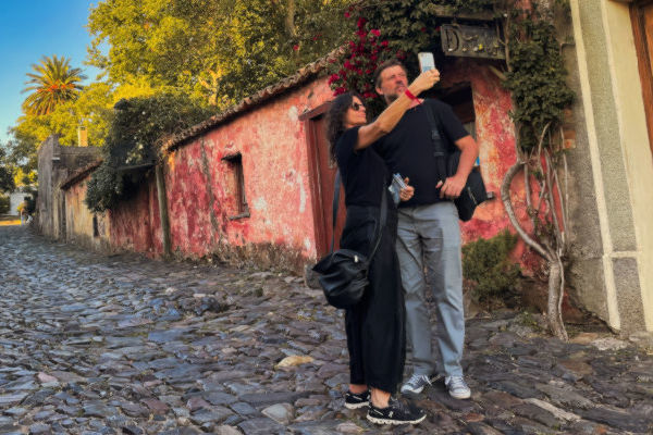 Turistas tomándose una selfie en una calle empedrada de Colonia del Sacramento, Uruguay.