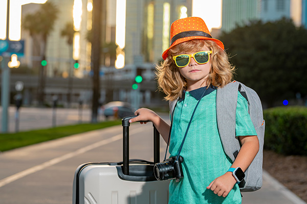 Niño turista con maleta y cámara de fotos