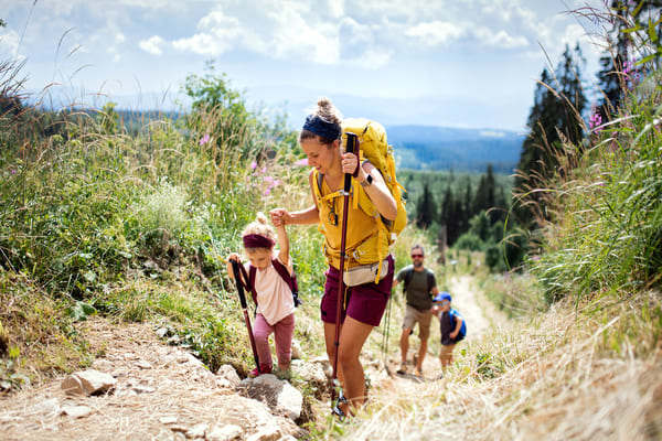 Familia haciendo senderismo en la montaña.