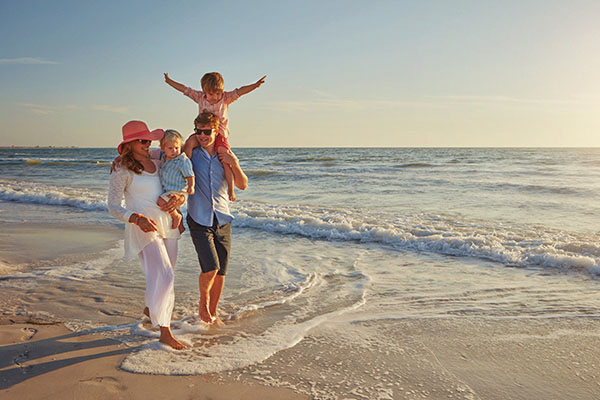 una familia alegre que pasea por la playa 