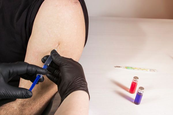 imagem de pessoa recebendo curativo após vacinação, em artigo de blog sobre certificado da vacina de febre amarela para viagens