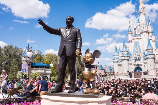 imagem da estátua de Walt Disney, com o Mickey e o Castelo da Cinderela ao fundo, para falar sobre viagem para a Disney